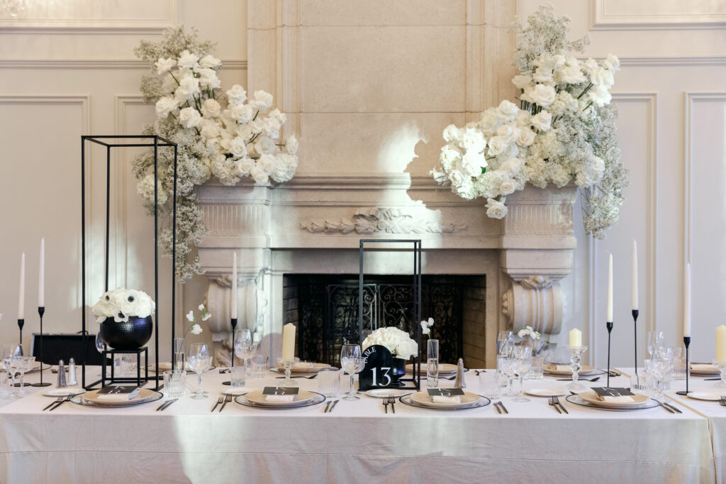 Black and white wedding decor by an ornate fireplace 