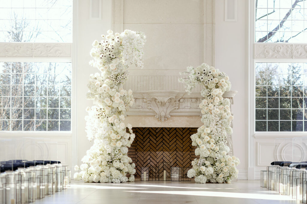 Ornate white fireplace decorated with luxury floral installations