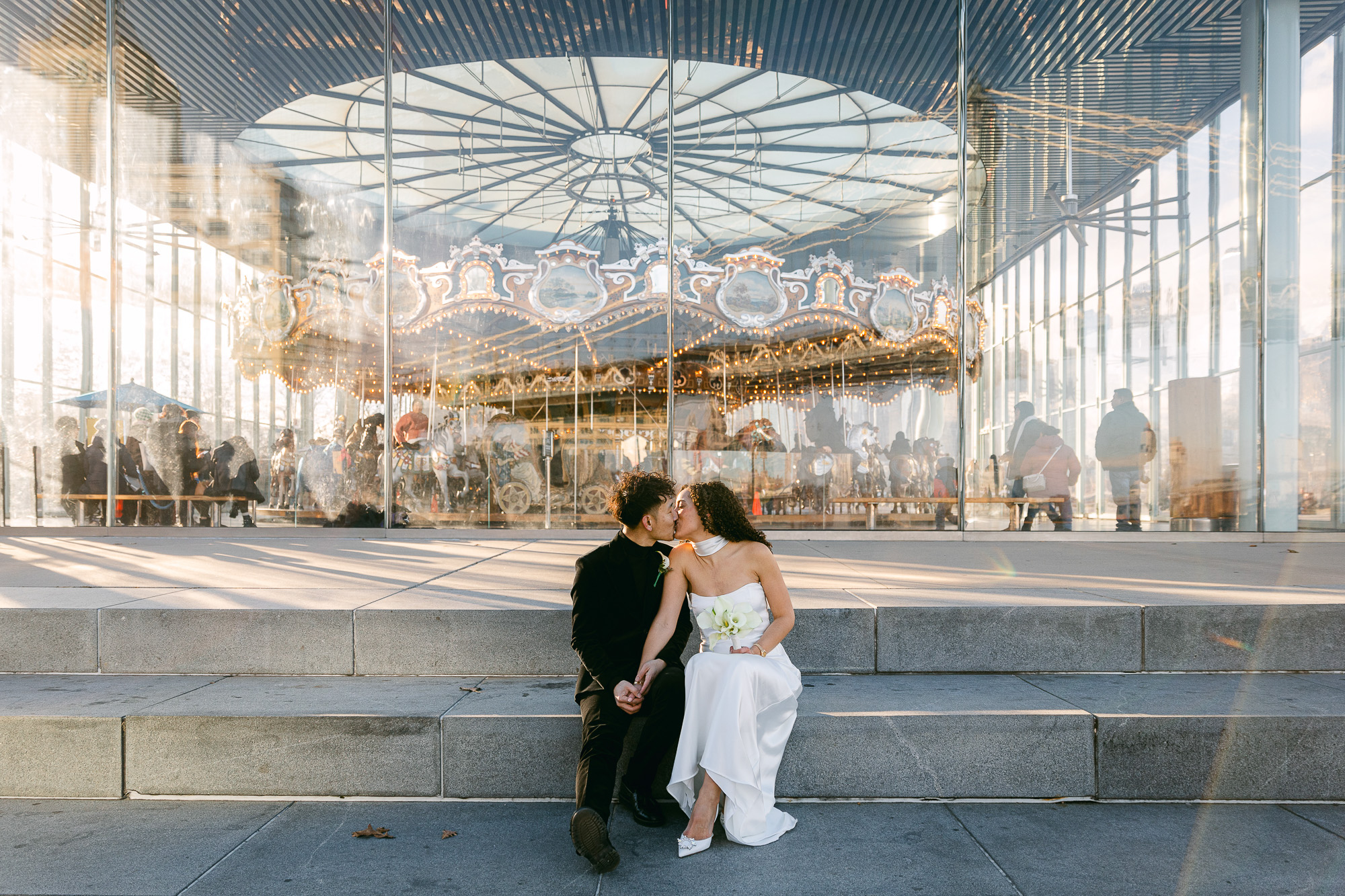 A couple kiss on the steps of Jane's Carousel in Brooklyn