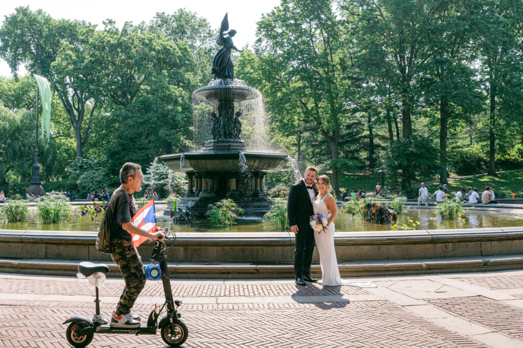 A couple takes wedding photos at the Bethesda Fountain